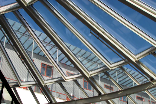Close-up of a sleek modern window reflecting a bright blue sky.