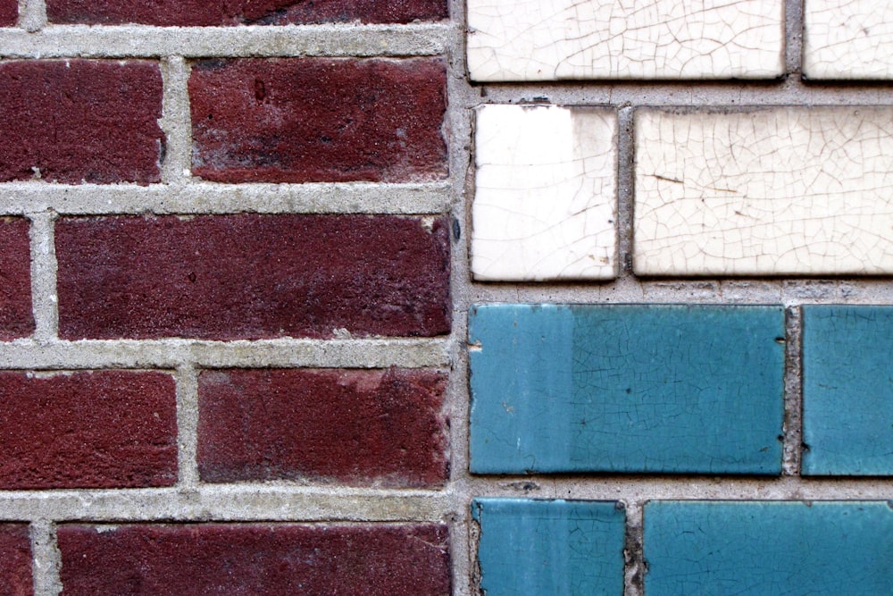 a close up of a brick wall with blue and white tiles
