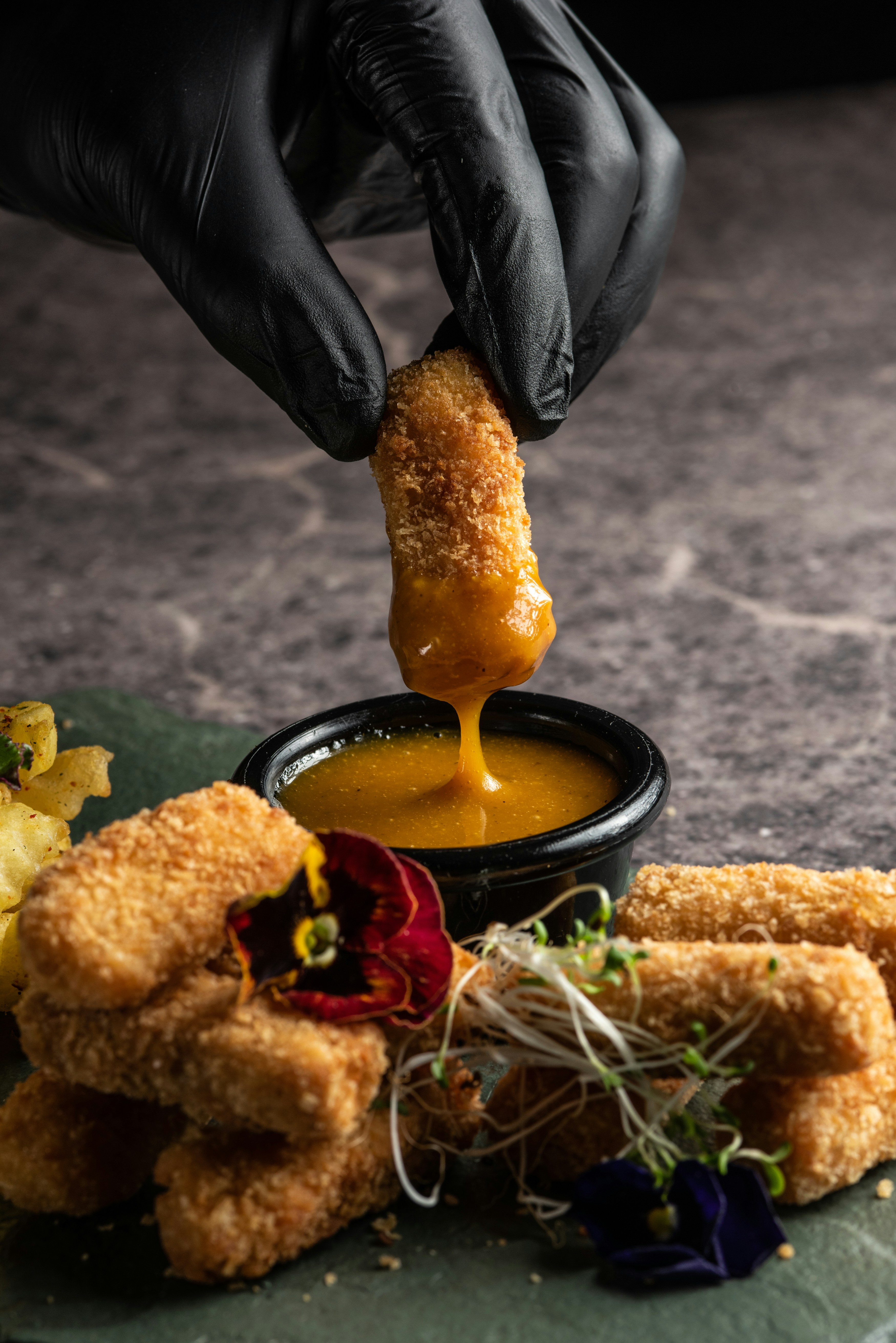 a person dipping something into a bowl of dipping sauce