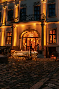 Modern clubhouse exterior with elegant Mediterranean architectural details and ambient lighting.