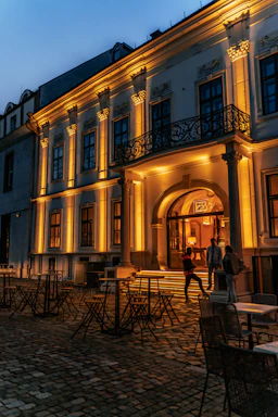 A warm, inviting view of the historic Coin Harvey House entrance bathed in soft evening light.