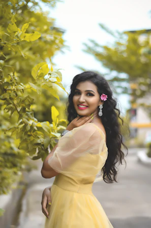 a woman in a yellow dress posing for a picture