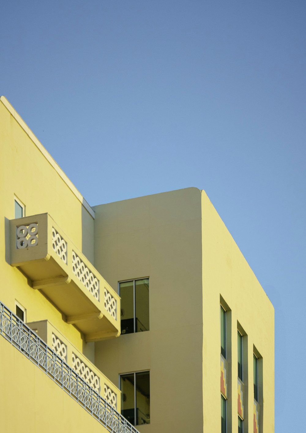 a yellow building with a balcony and balconies