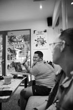A sleek black and white photo of a consultant discussing plans with a client over a laptop.