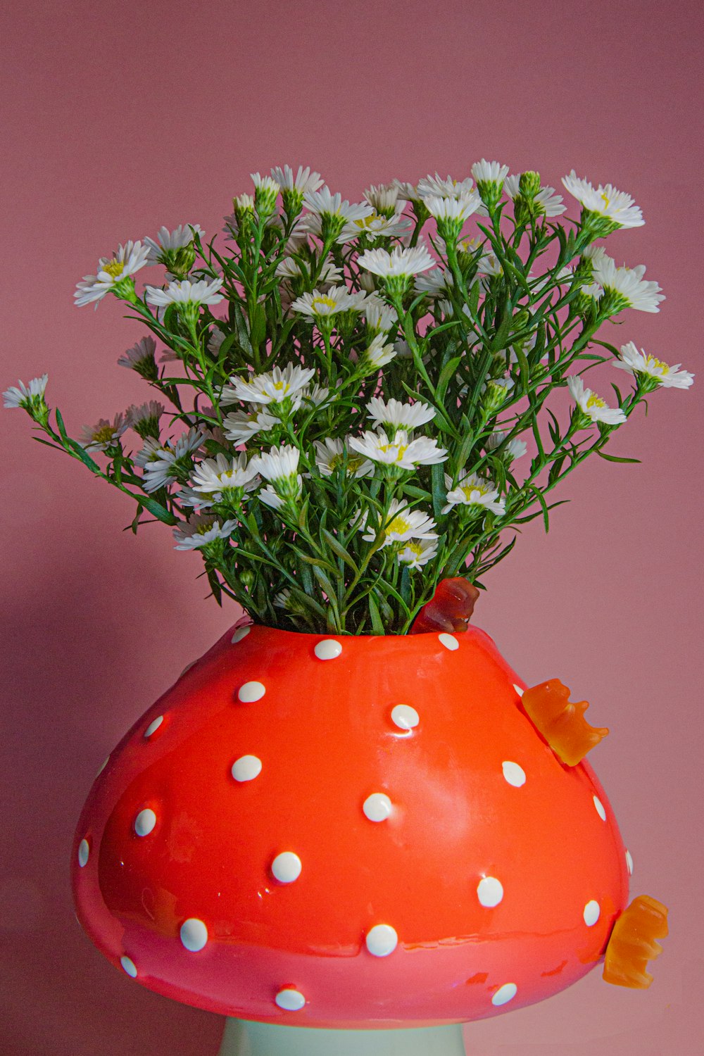 a mushroom vase with daisies and daisies in it