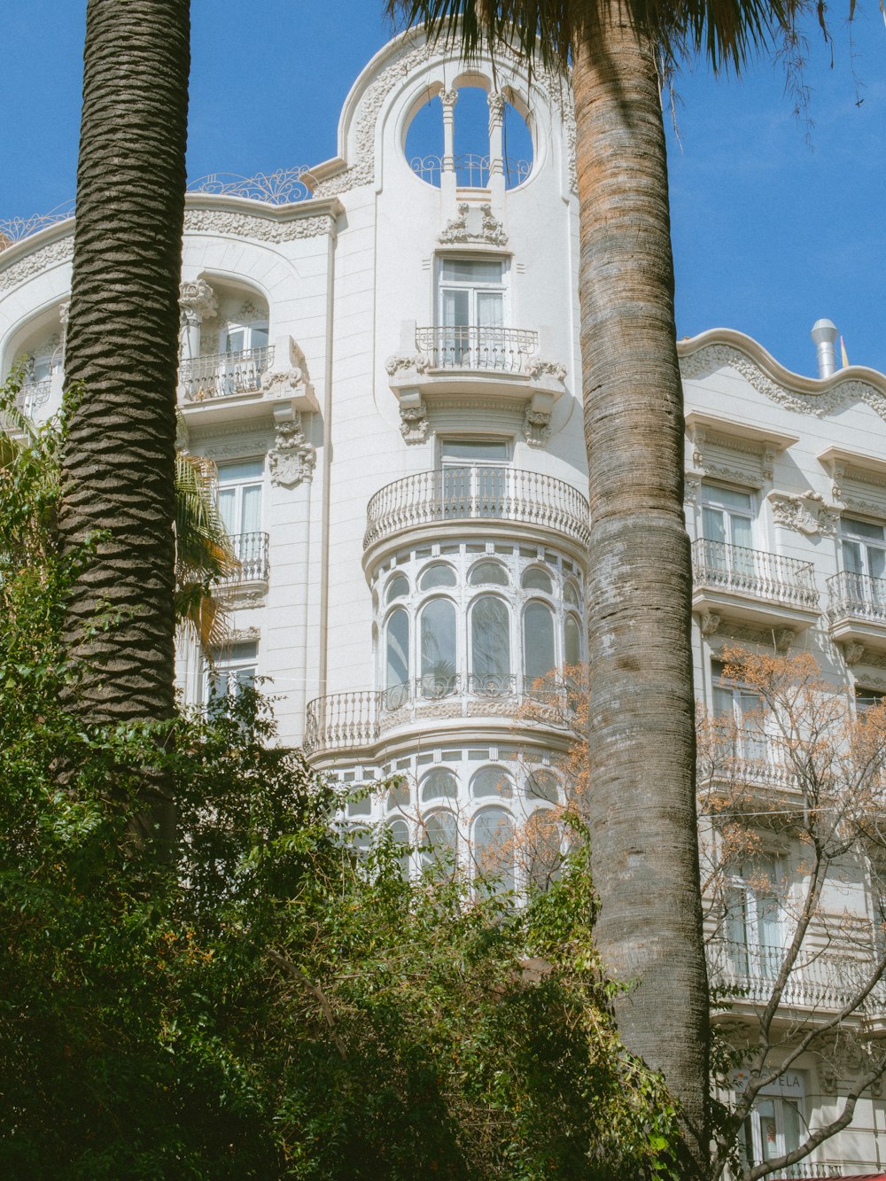 a tall white building with a clock on the front of it