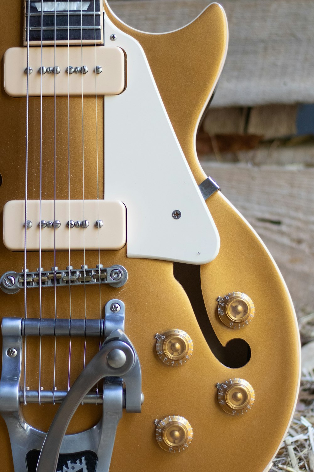 a close up of an electric guitar on a wooden surface