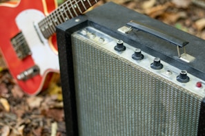 A vibrant red JS electric guitar leaning on a vintage amplifier, capturing the vibrant energy of the instrument.