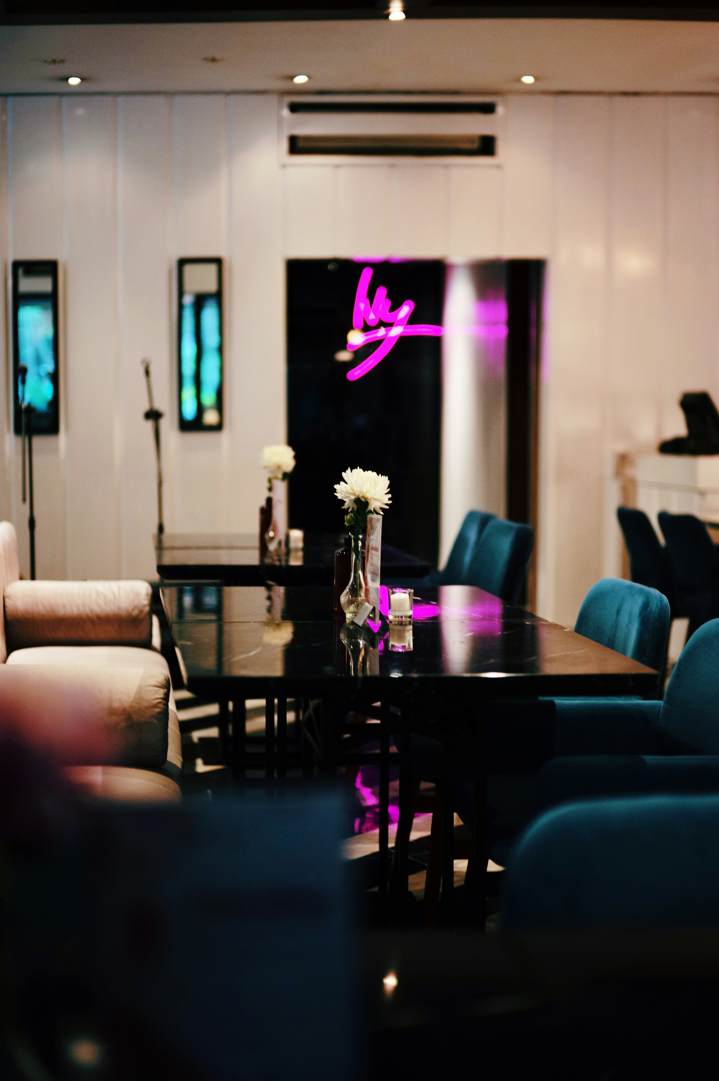 Vibrant pink neon bar sign glowing in dark atmospheric lounge interior