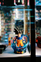 Striking vertical card of Goku in Ultra Instinct stance, glowing with silver aura.