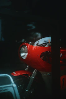 Dynamic shot of a motorcycle headlamp and stoplamp combo glowing in red and black tones