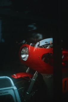 Sleek motorcycle LED lamp mounted on a red bike under soft sunlight