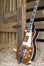 A vintage electric guitar leaning against a wooden crate filled with Heller beer bottles, evoking a raw rock vibe.