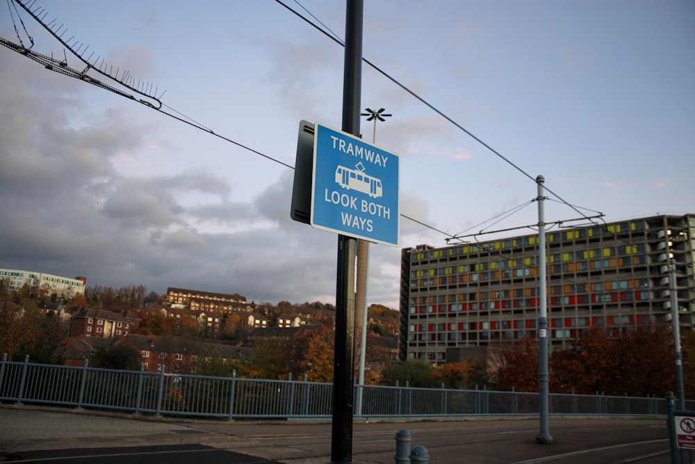 a blue street sign sitting on the side of a road