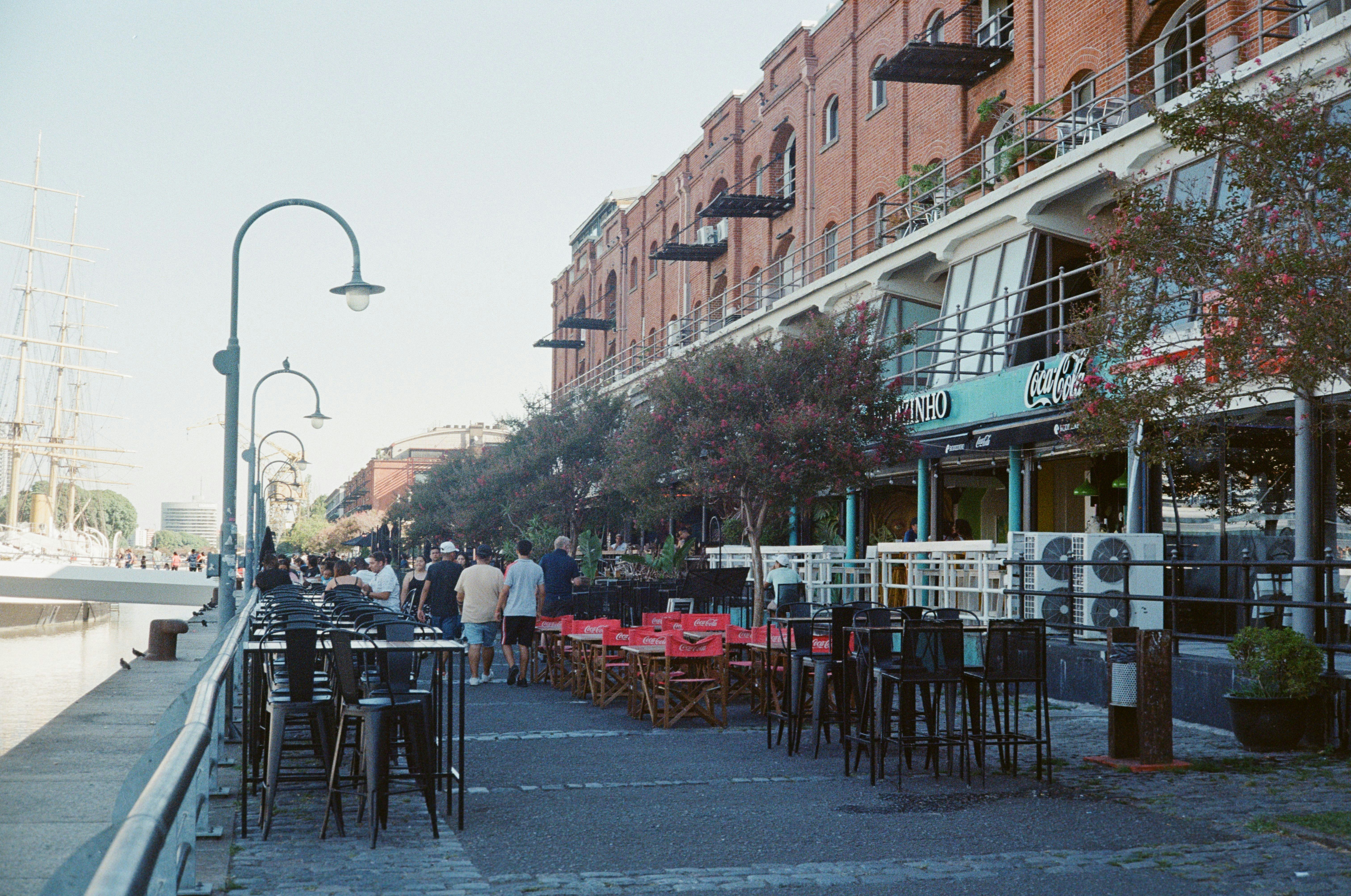 Un grupo de personas caminando por una calle junto a edificios altos
