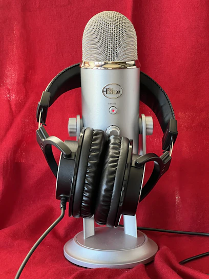 Elegant radio studio with black and gold decor, featuring a microphone and headphones.