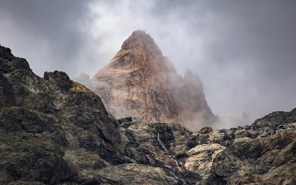 a very tall mountain in the middle of a cloudy sky