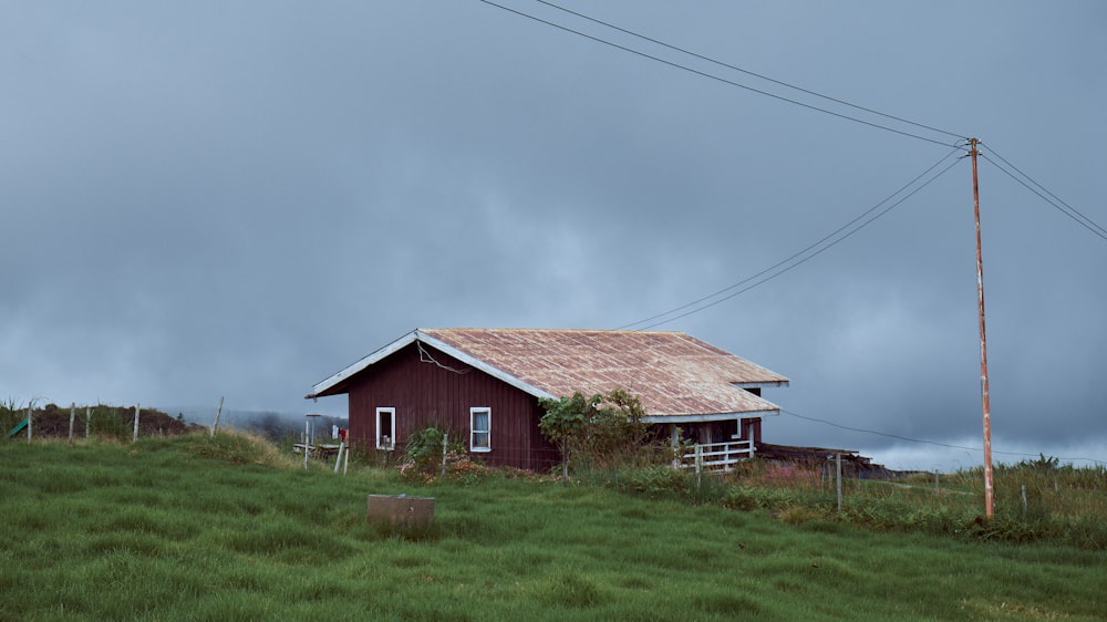 a red house sitting on top of a lush green hillside