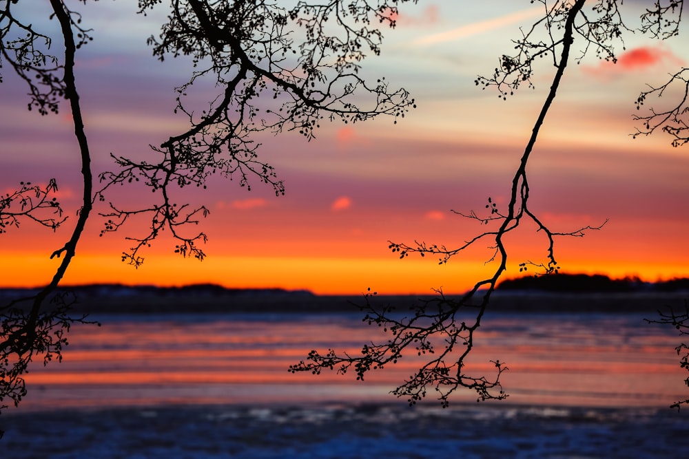 the sun is setting over a body of water