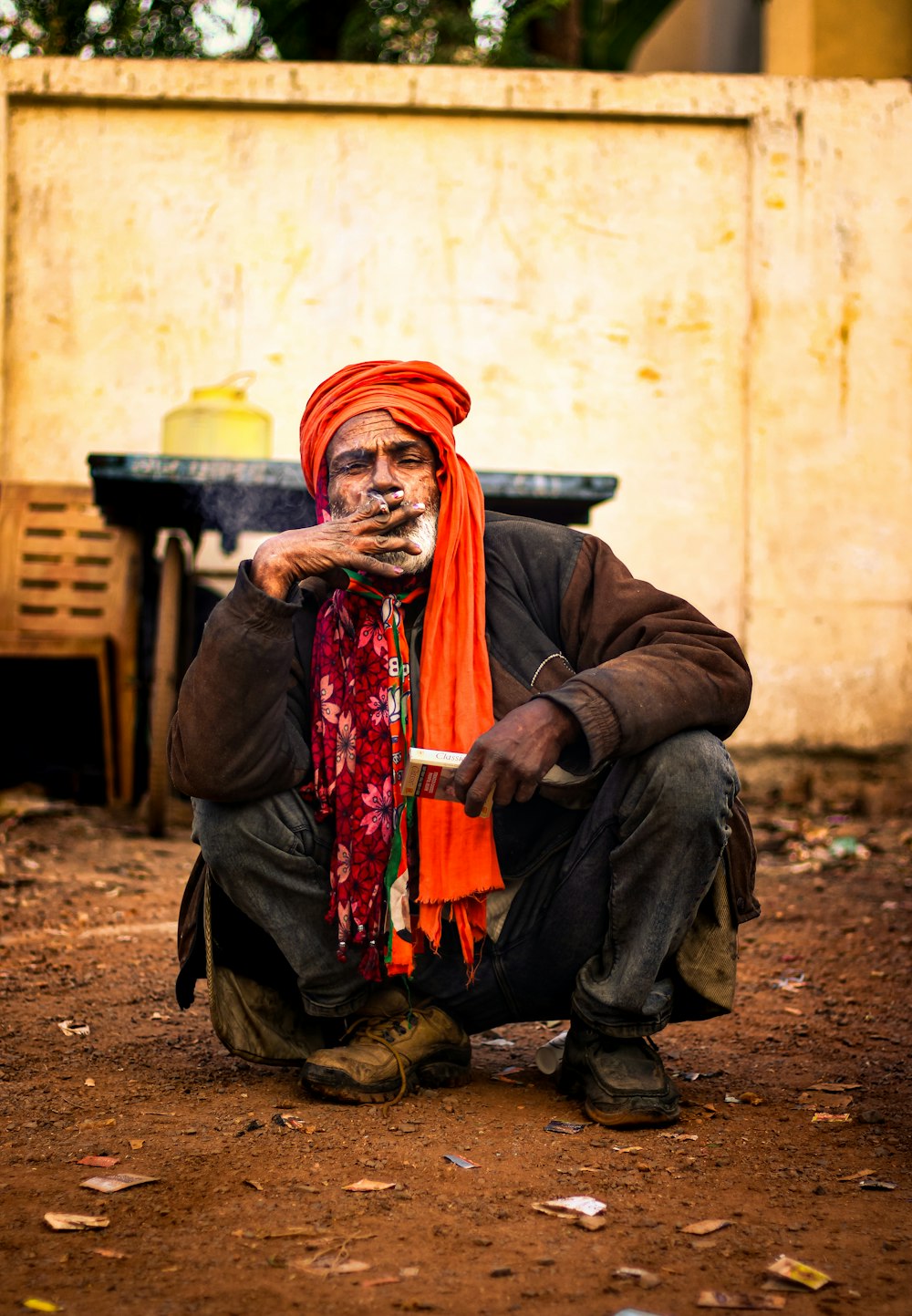 a man in an orange turban smoking a cigarette