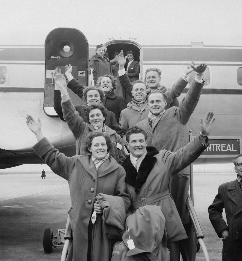 a group of people standing in front of an airplane