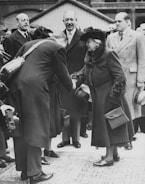 A professional agent shaking hands with a seller in a modern living room.