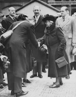 A group of international delegates shaking hands at a formal economic diplomacy conference.