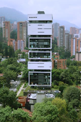 a tall white building sitting in the middle of a forest