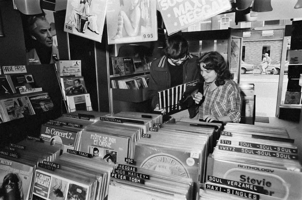 a black and white photo of a woman at a record store