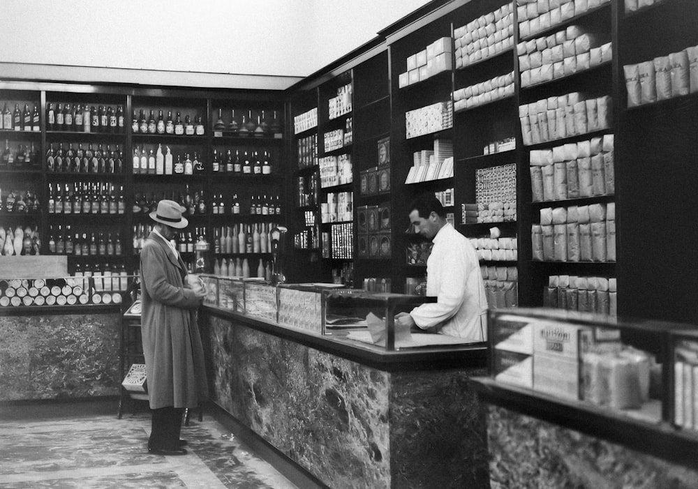 a couple of men standing at a counter in a store