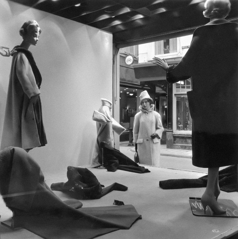 a black and white photo of mannequins in a store window