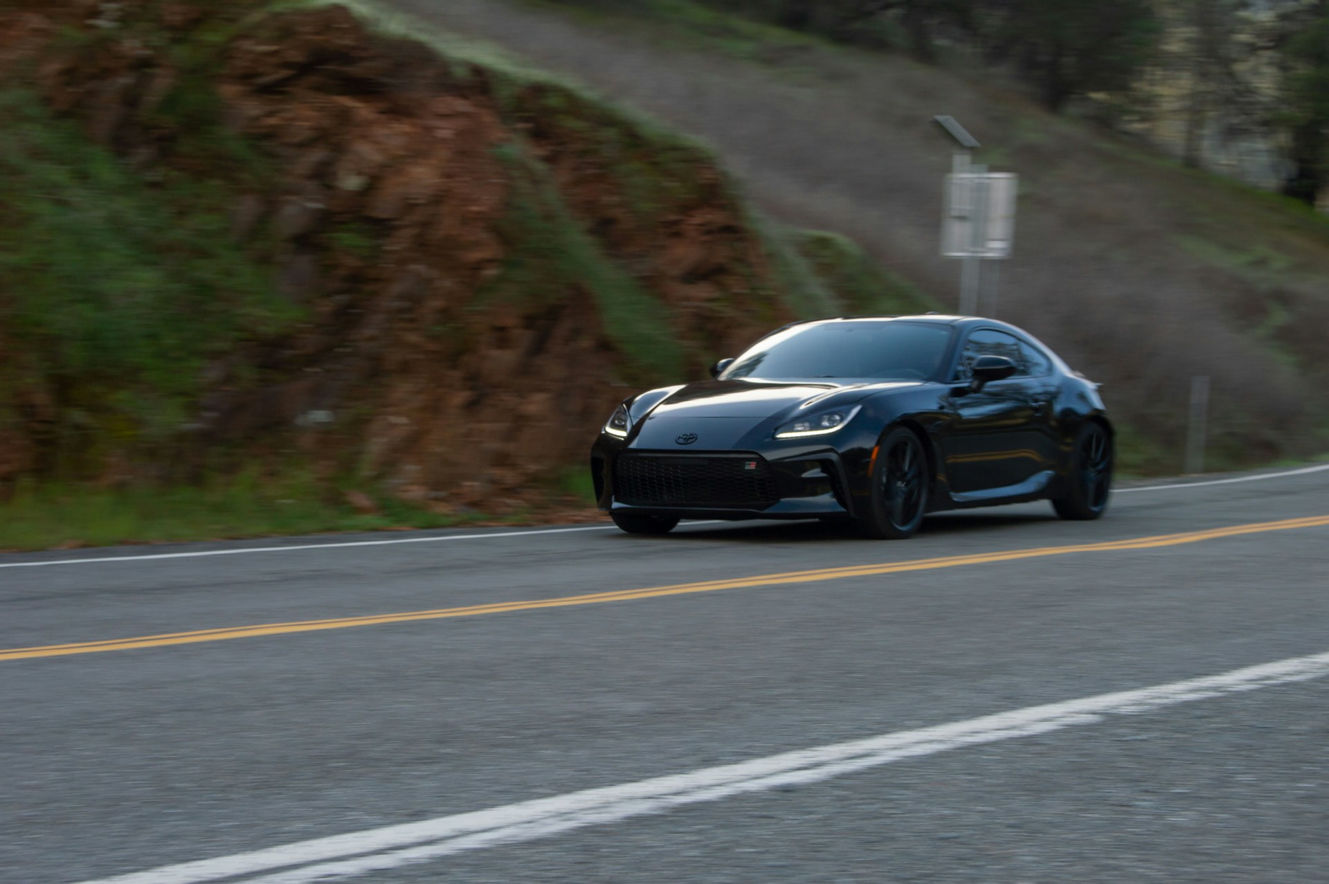 a black sports car driving down the road