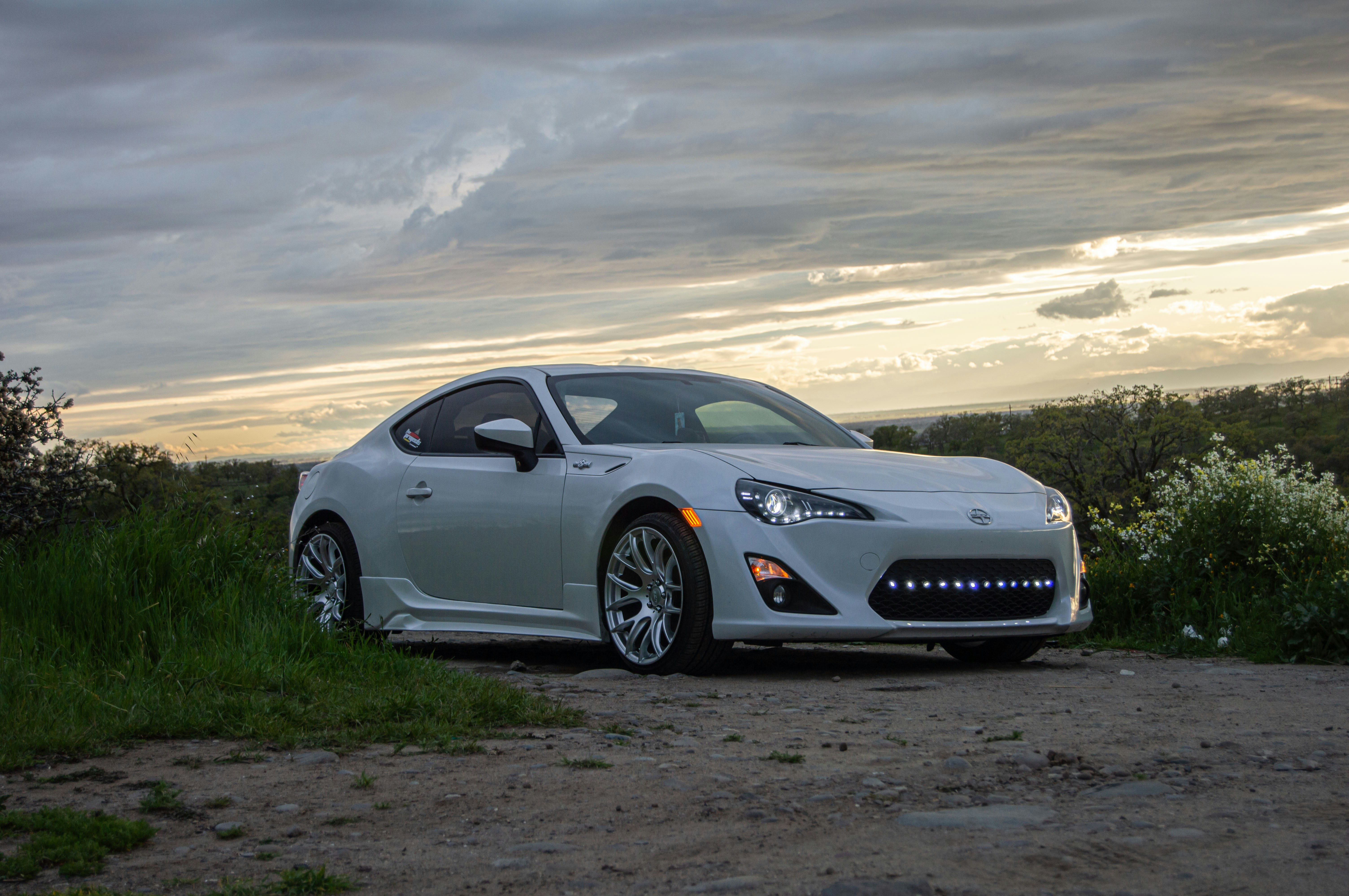 a white sports car parked on a dirt road
