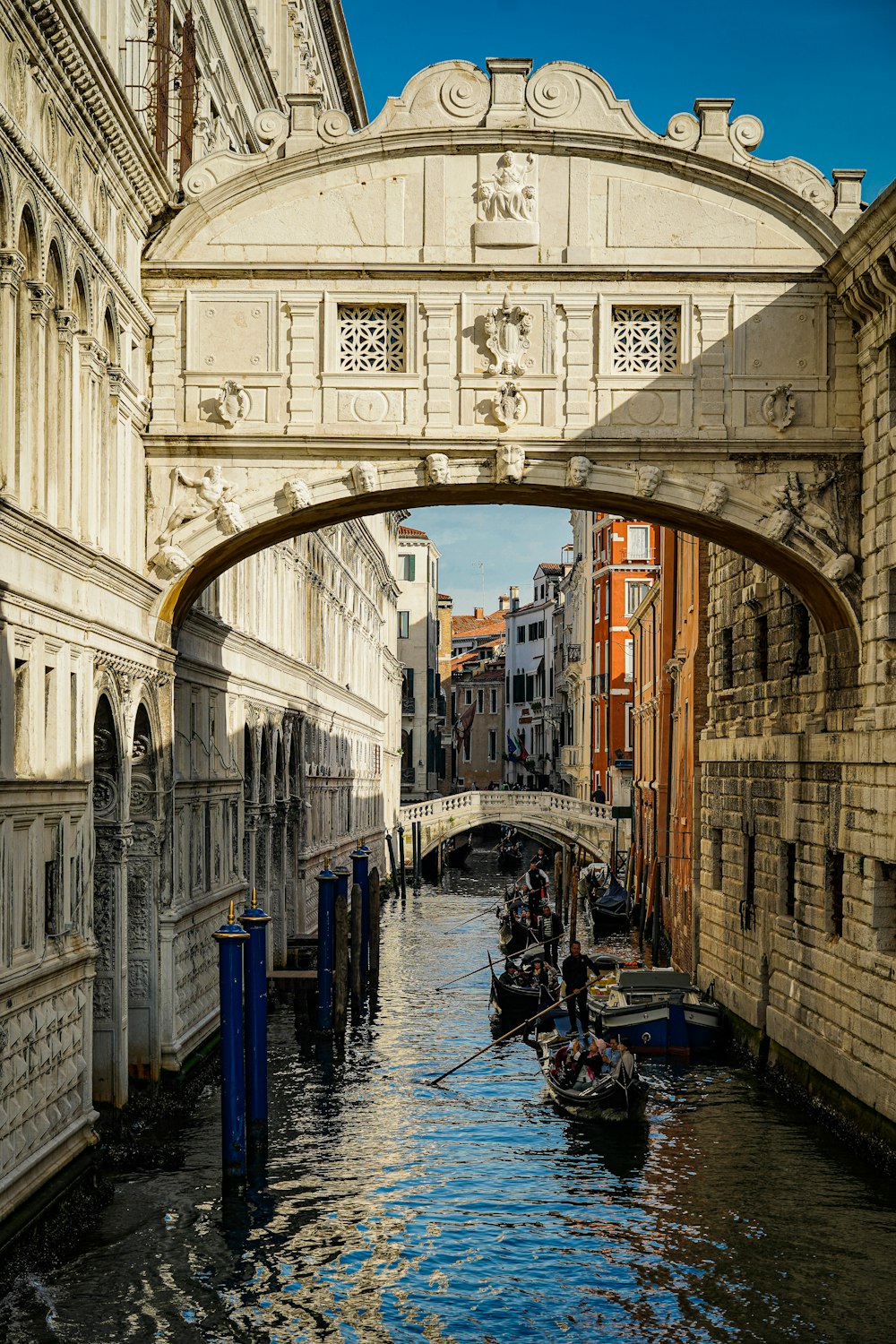 a couple of boats floating under a bridge