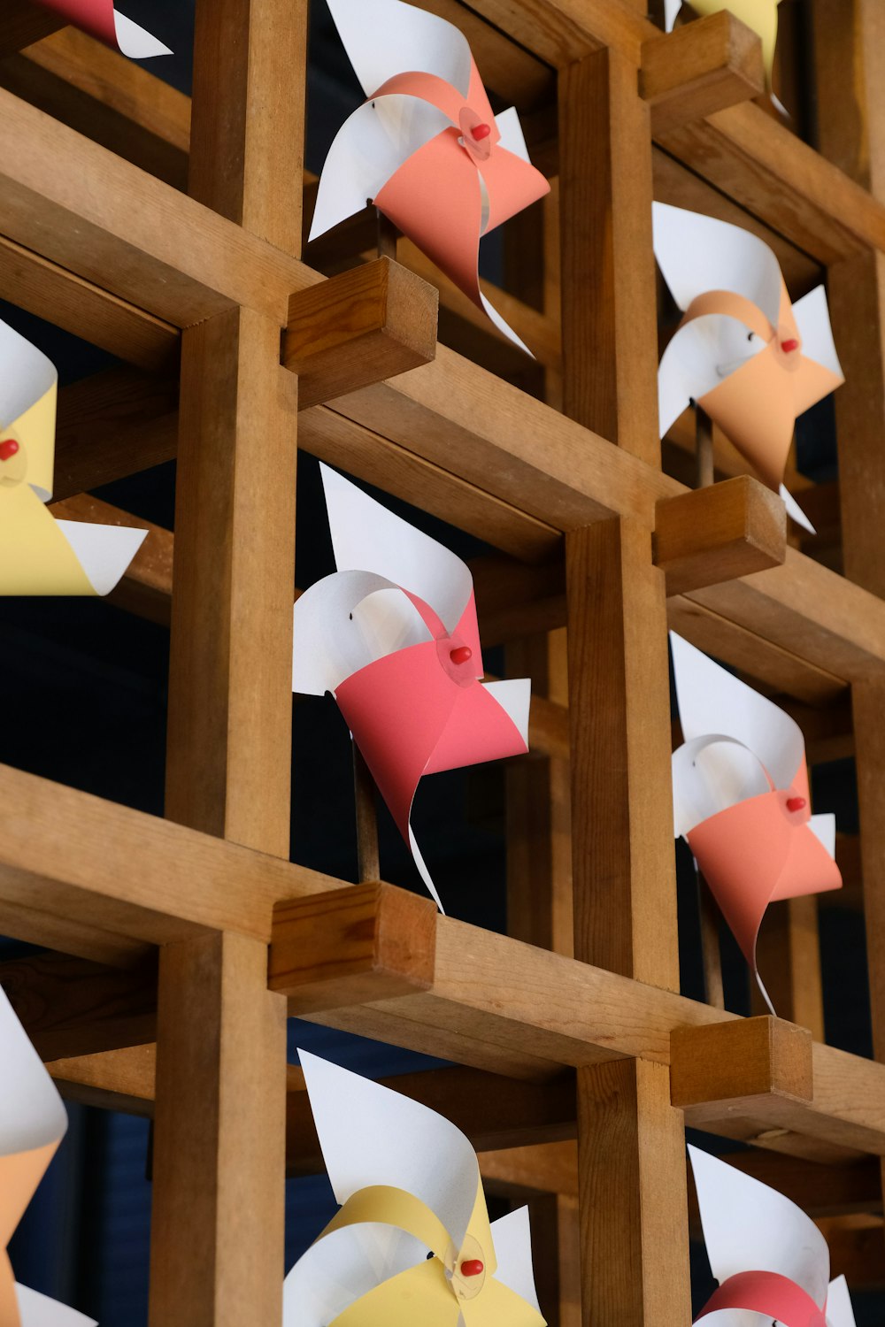 a group of paper birds hanging from a wooden wall