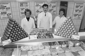 Friendly staff assisting a customer with meat selection at the counter.