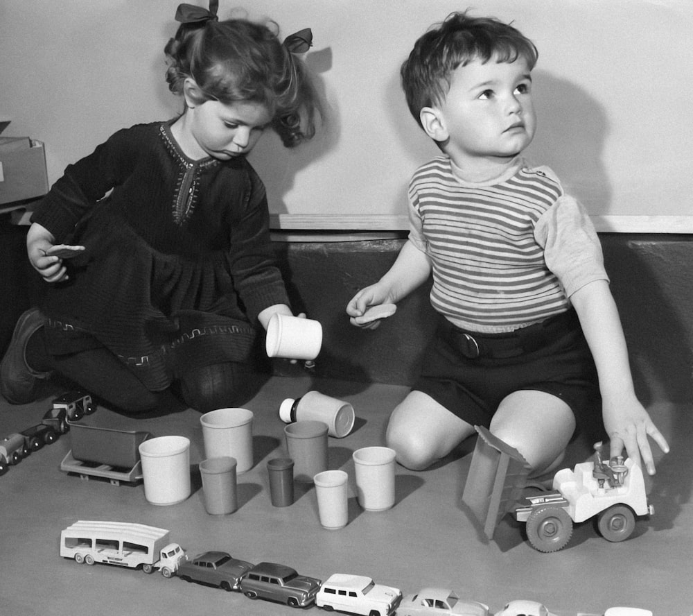 two little girls playing with toys on the floor