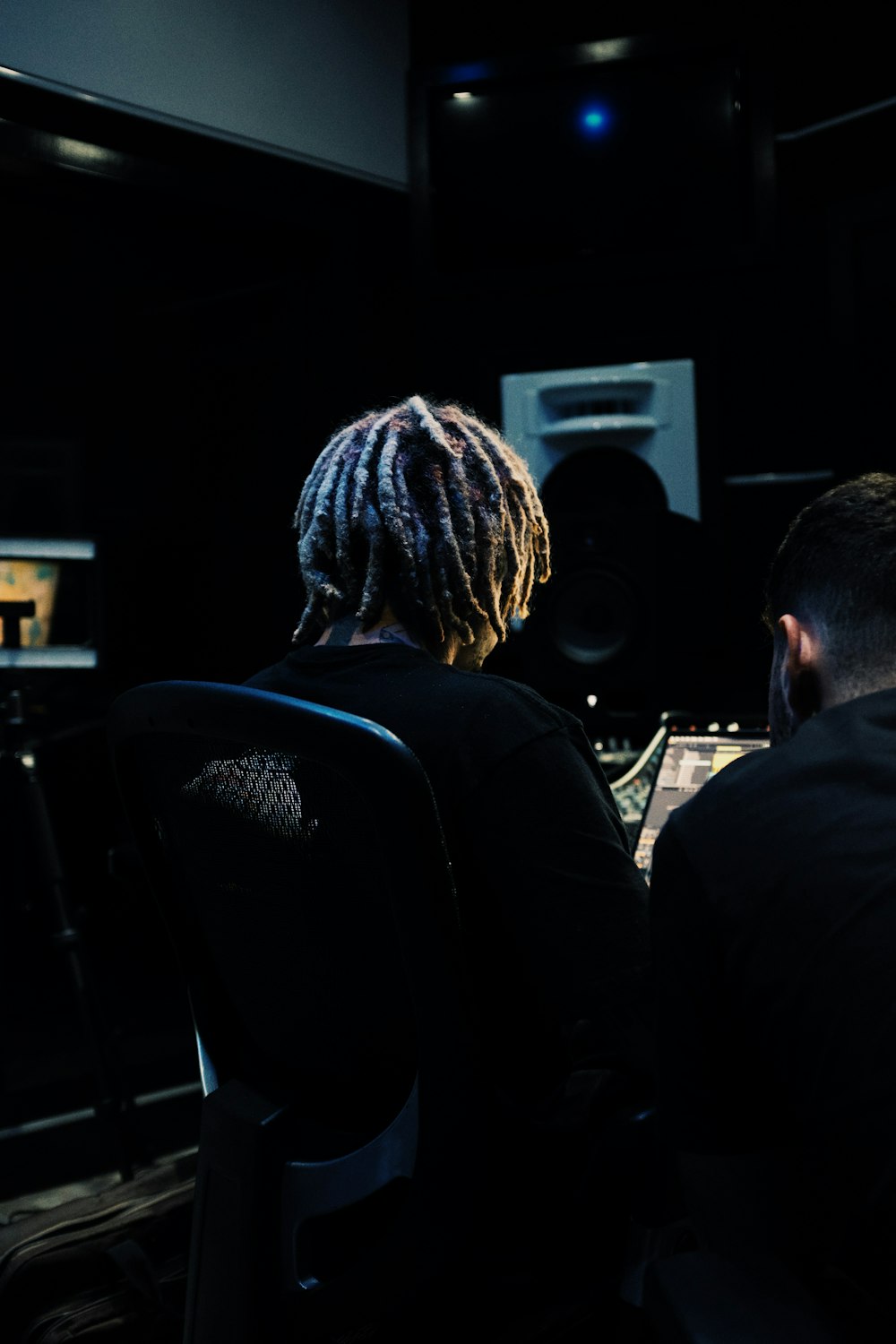 a man and a woman sitting in front of a mixing desk