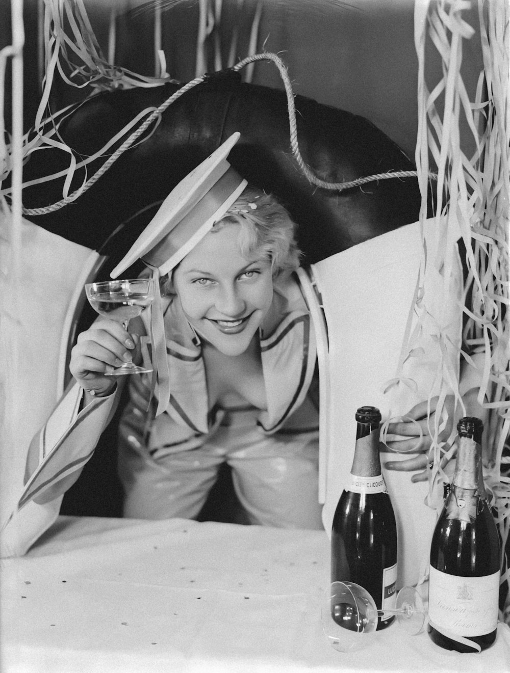 a black and white photo of a woman holding a wine glass
