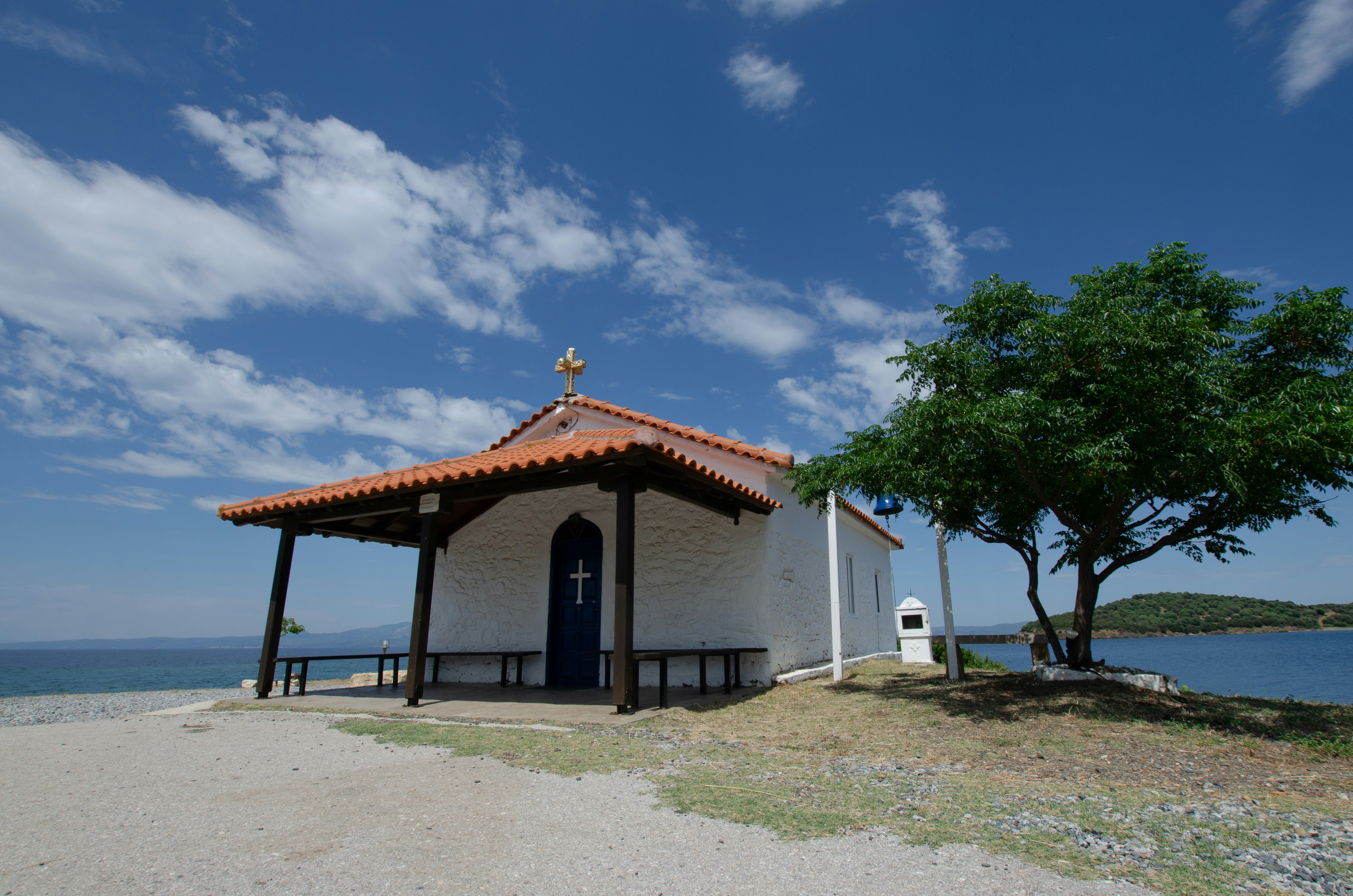a small white building sitting next to a body of water