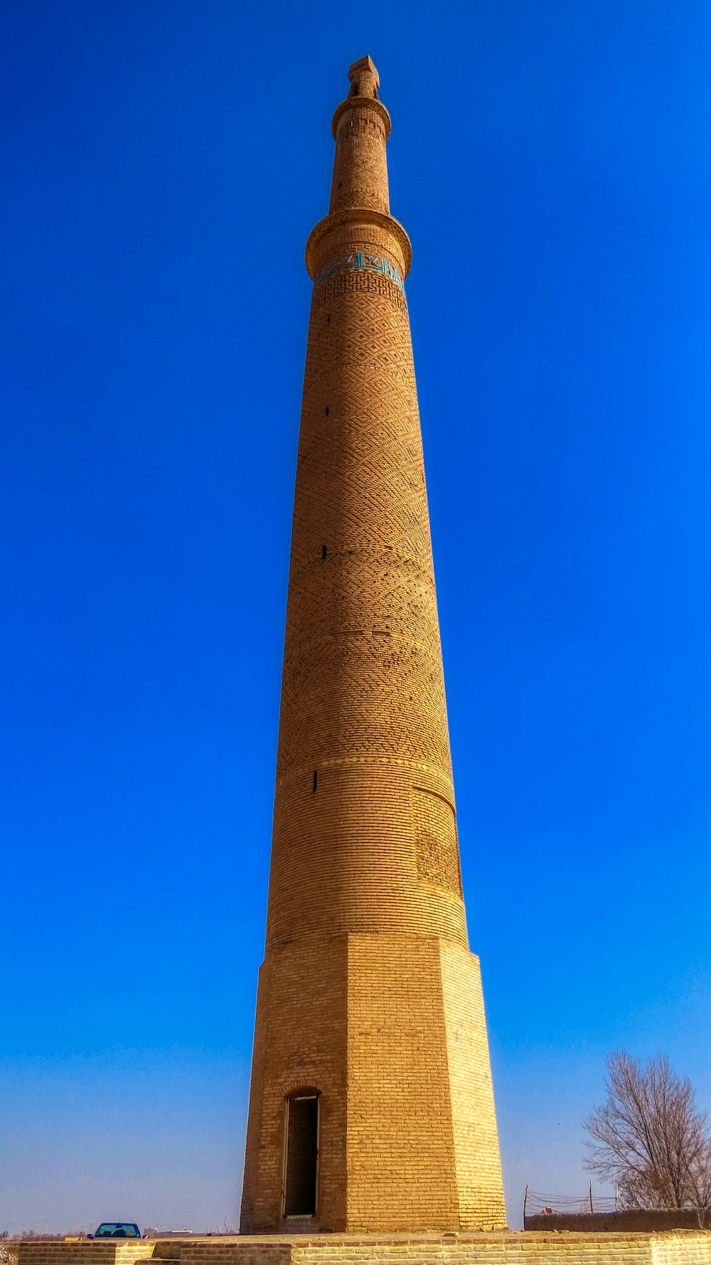 Ein hoher Backsteinturm mit einer Uhr auf der Spitze