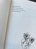 A page from a book featuring a short poem in Spanish about the resilience of the human heart. Below the poem, there is a minimalistic line drawing of a heart intertwined with blooming flowers.