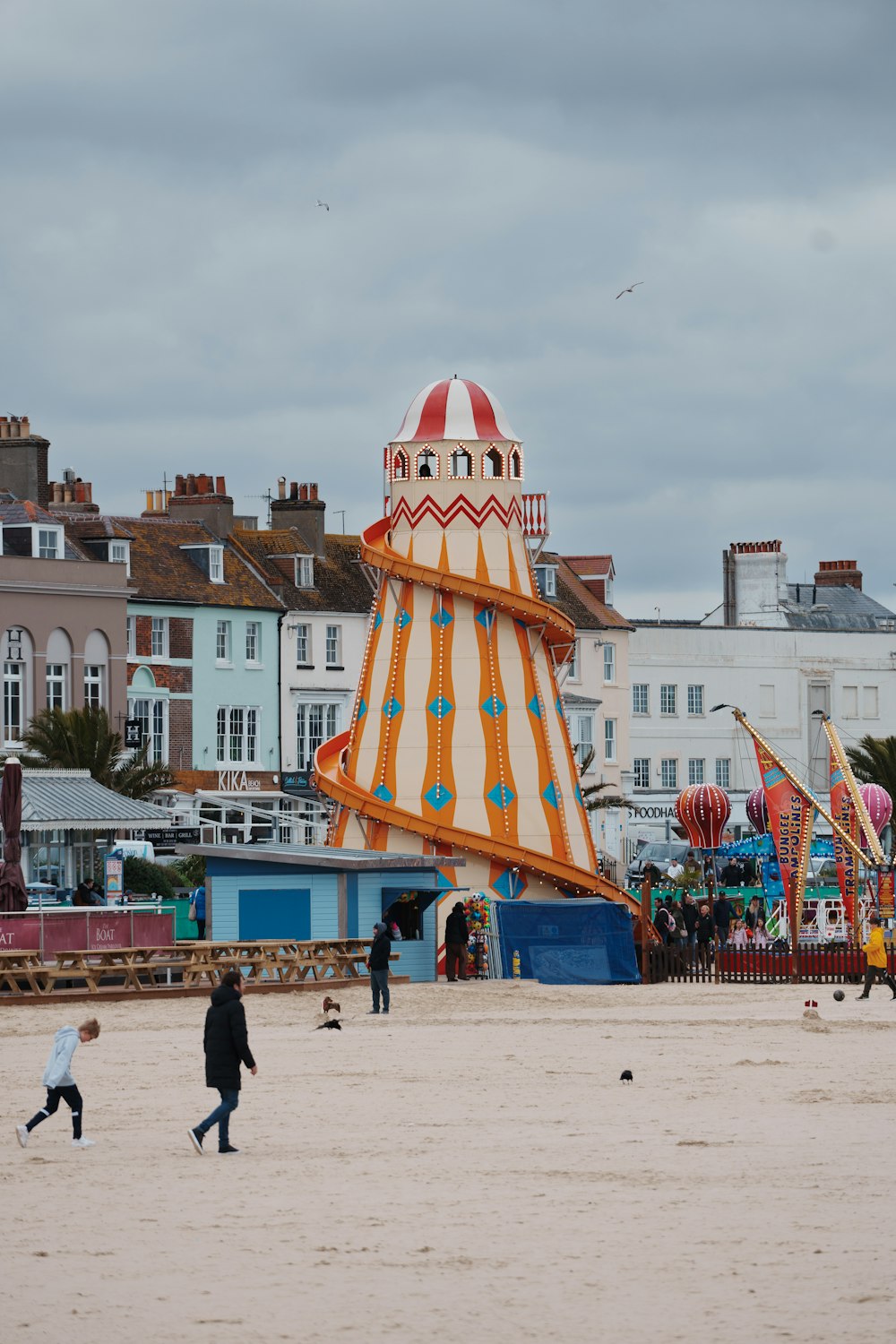 a carnival ride on the beach with people walking around