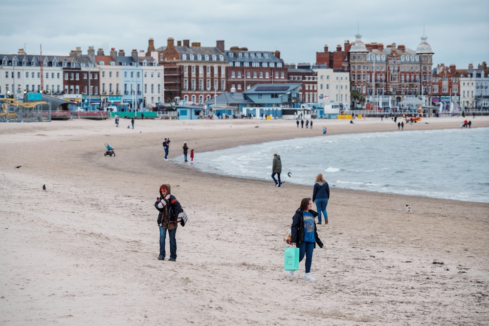 a group of people walking along a sandy beach