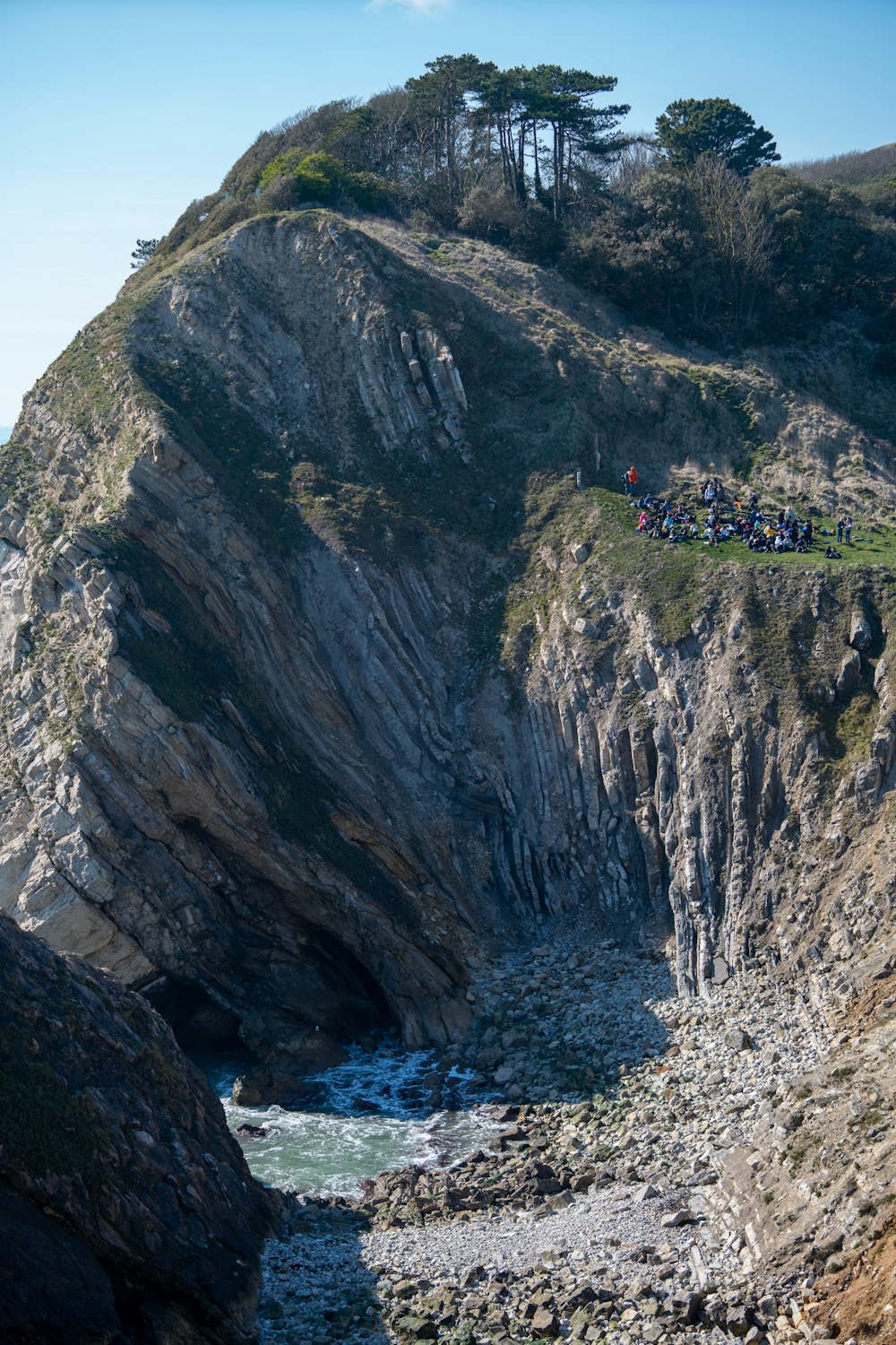 a group of people standing on top of a cliff