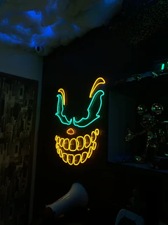 A sultry neon-lit room with the troll face mascot glowing softly in the background.