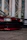 Side view of a red car with glossy finish parked in front of the Pepe Car´s shop.