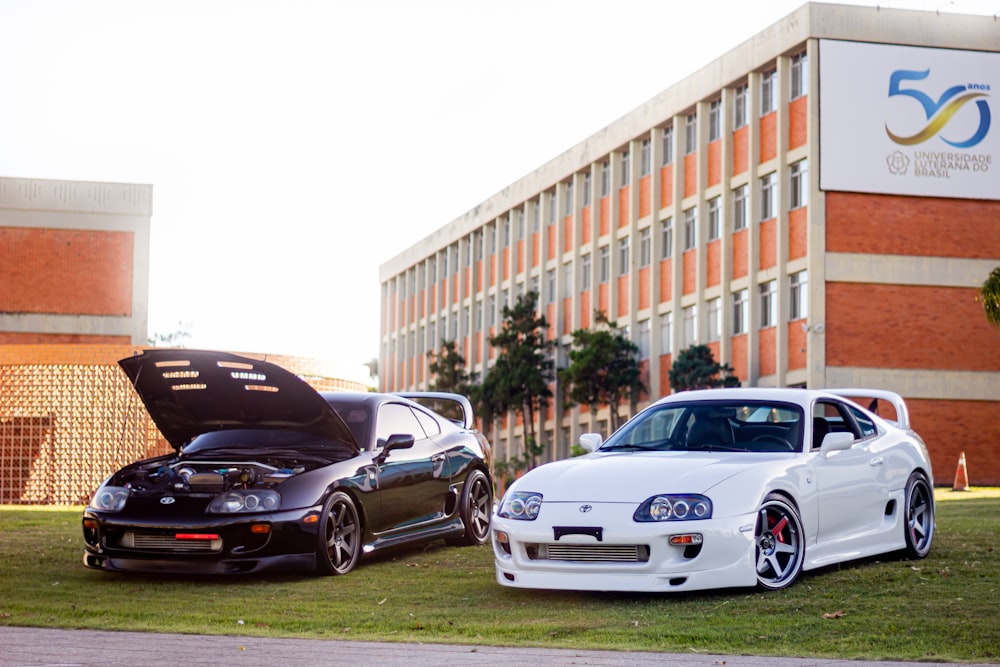 two cars parked next to each other in front of a building