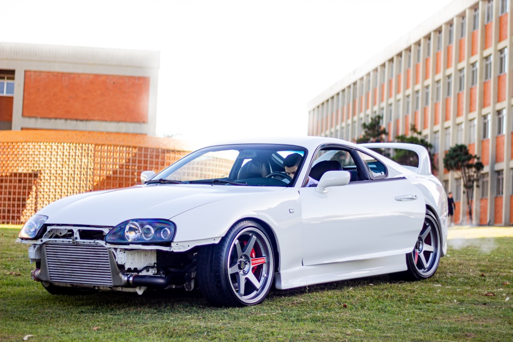 a white sports car parked in front of a building