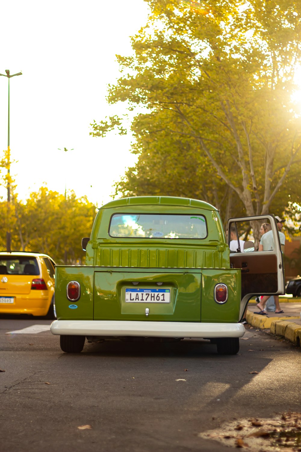 uma caminhonete verde dirigindo por uma rua